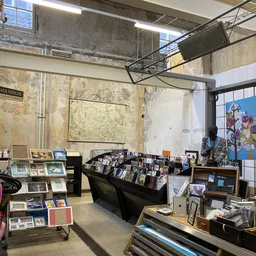 Kringloopwinkel interieur met boeken en media in zwarte display kasten, stellingen met artikelen en raamuitstalling
