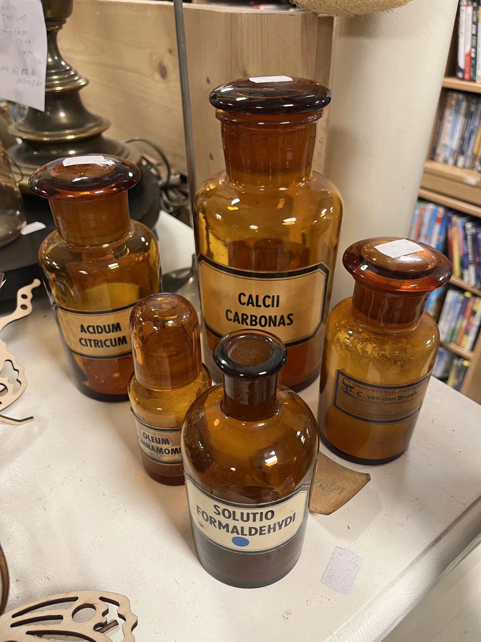 Verzameling antieke apothekersflessen van bruin glas met labels, waaronder Acidum Citricum en Calcii Carbonas