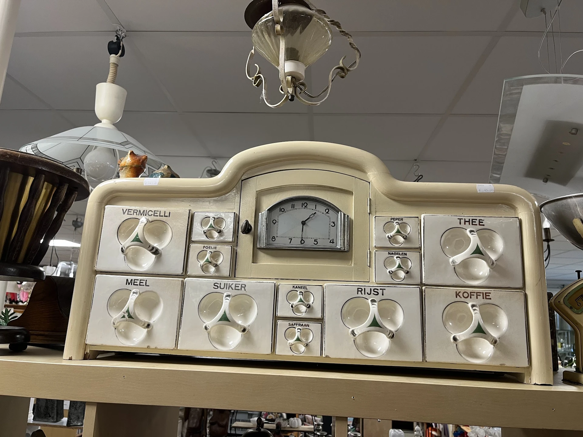 Vintage mengpaneel met meerdere draaiknoppen en centrale klok, gebruikt voor portieverdeling in een oud huishouden