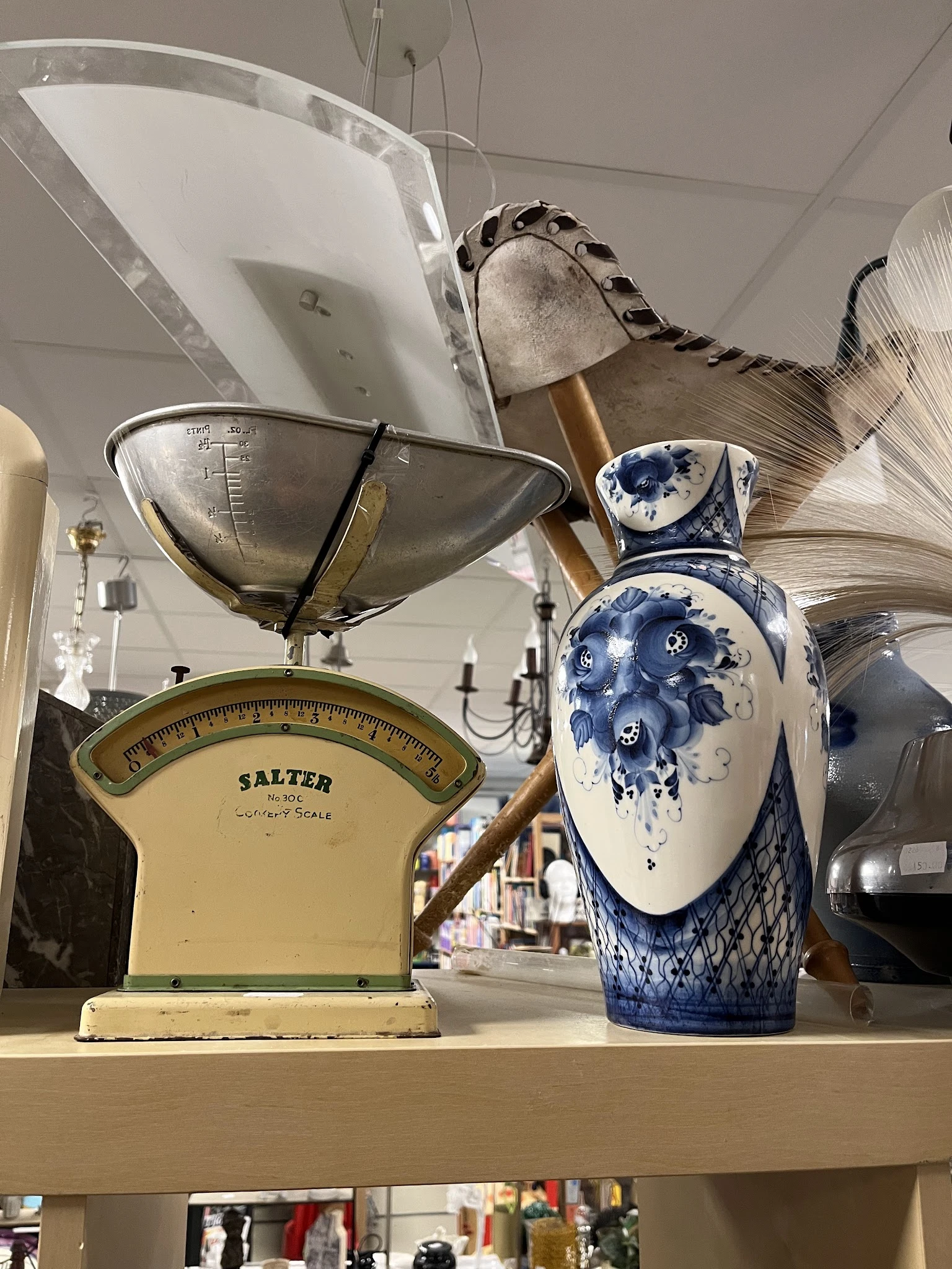 Vintage Salter weegschaal en blauw-wit decoratief aardewerk in een kringloopwinkel