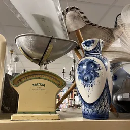 Vintage Salter weegschaal en blauw-wit decoratief aardewerk in een kringloopwinkel