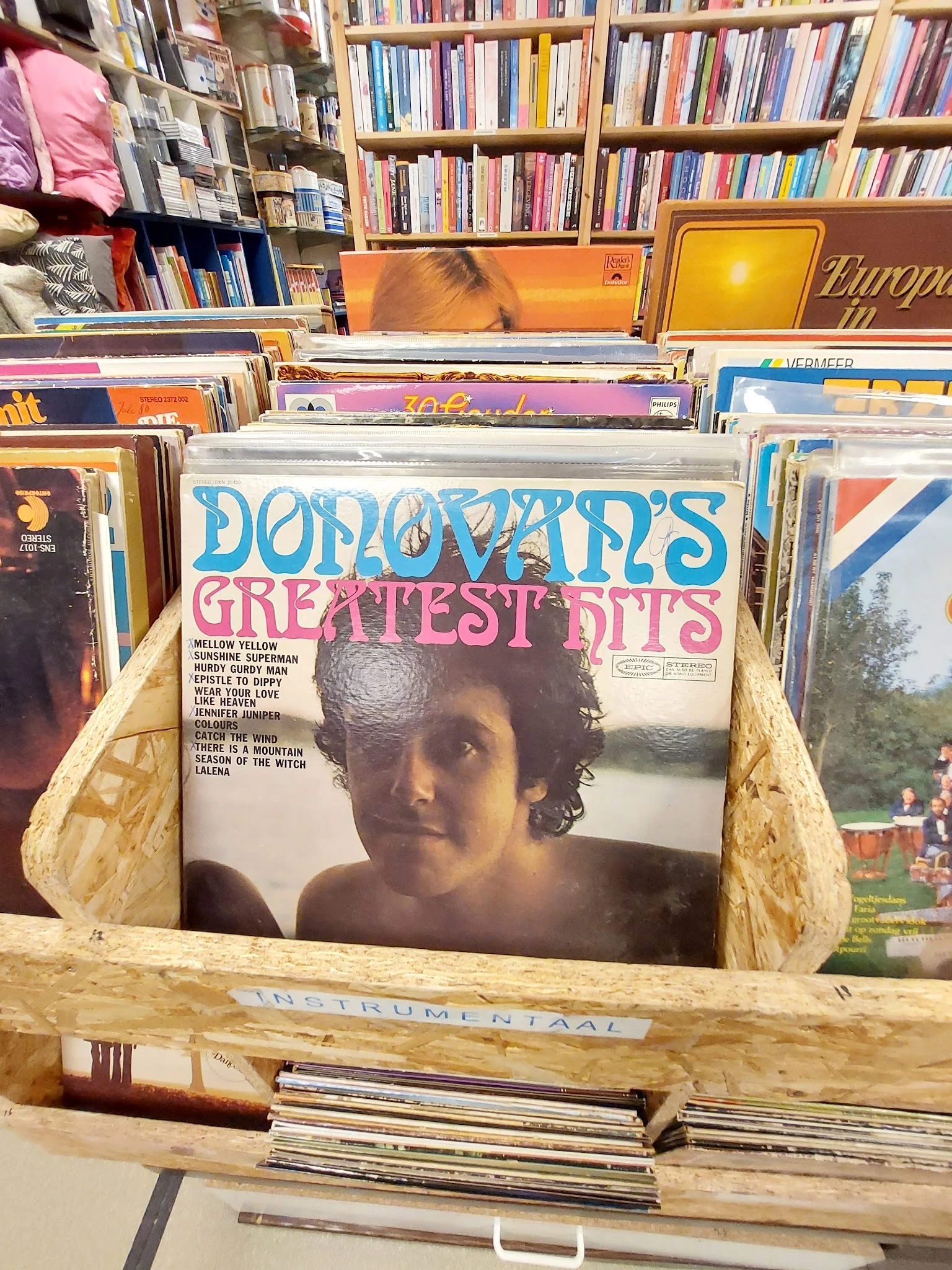 Vinyl LP's in een kringloopwinkel, waaronder 'Donovan's Greatest Hits' prominent zichtbaar