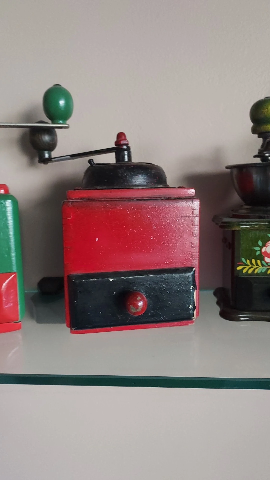 Rode en zwarte vintage koffiemolen met metalen bovenkant op display