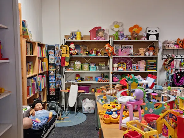 Speelgoedafdeling in kringloopwinkel met speelgoed, poppen, boeken en knuffels op stellingen en vloer