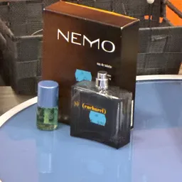 Close-up van twee flesjes parfum, waarvan één in verpakking met NEMO-branding en één los flesje met blauwe dop