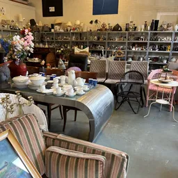 Winkelvloer met tafels, stoelen en kasten vol huishoudelijke artikelen en decoratiestukken