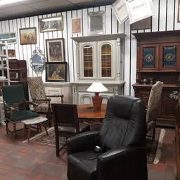 Vintage interieur met antieke meubels, schilderijen aan de muur, kasten met glasdeuren en diverse decoratieve items