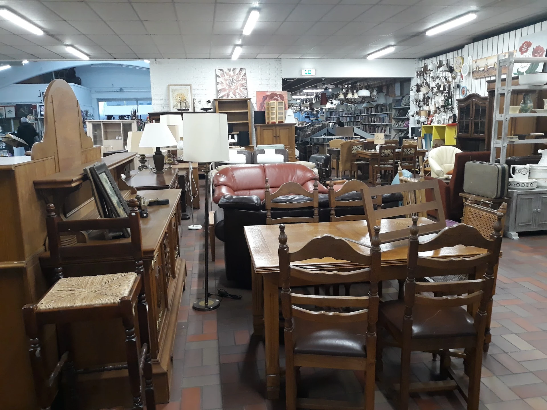 Winkelvloer met houten meubels, stoelen, banken en diverse huishoudspullen