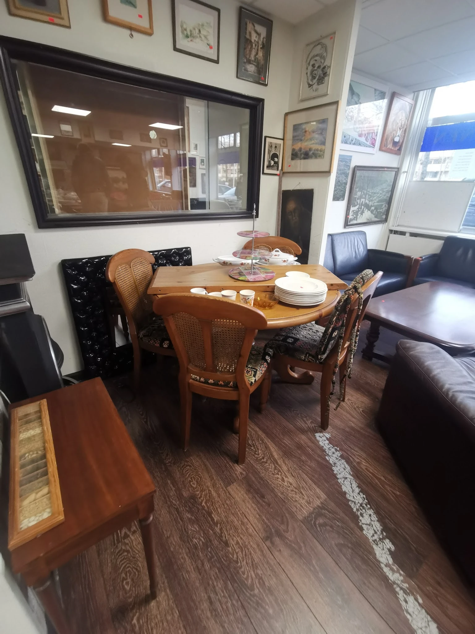 Woonkamer interieur met houten eettafel, rieten stoelen en donkerblauwe bank
