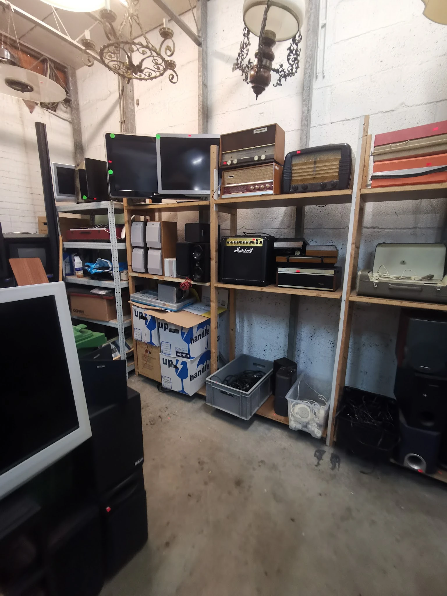 Houten stellingen met elektronische apparatuur zoals beeldschermen, versterkers, speakers en andere audio-apparatuur