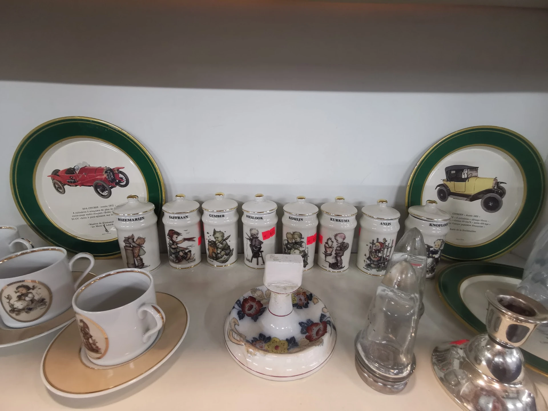 Verzameling vintage serviesgoed met vintage auto-afbeeldingen, waaronder borden, bekers en decoratieve items