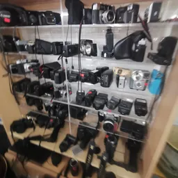 Vitrinekast met verzameling tweedehands camera's, flitsers en fotografische apparatuur