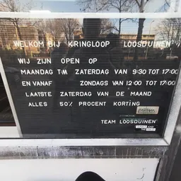 Openingstijden en informatie op een letterbord in een winkel
