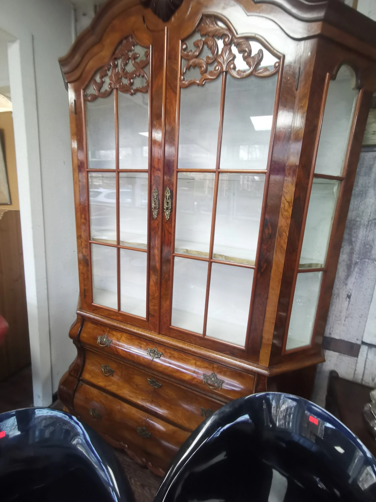 Houten vitrinekast met glazen deuren en lade, donkerbruin ingelegd houtwerk met decoratieve elementen