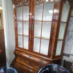Houten vitrinekast met glazen deuren en lade, donkerbruin ingelegd houtwerk met decoratieve elementen