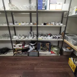 Stellingen met servies, borden en kopjes in een kringloopwinkel
