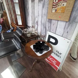 Bruine ronde tafel met zwarte handschoenen, naast een Coca-Cola bord en andere winkelspeullen