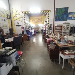 Overzicht van de winkelvloer met stellingen, tafels met spullen en decoraties langs de zijkanten