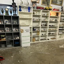 Winkelvloer met grijze en witte stellingen vol decoratieve items, vazen en huishoudartikelen