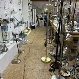 Winkelinterieur met staande lampen en armaturen uitgestald op beige vloer