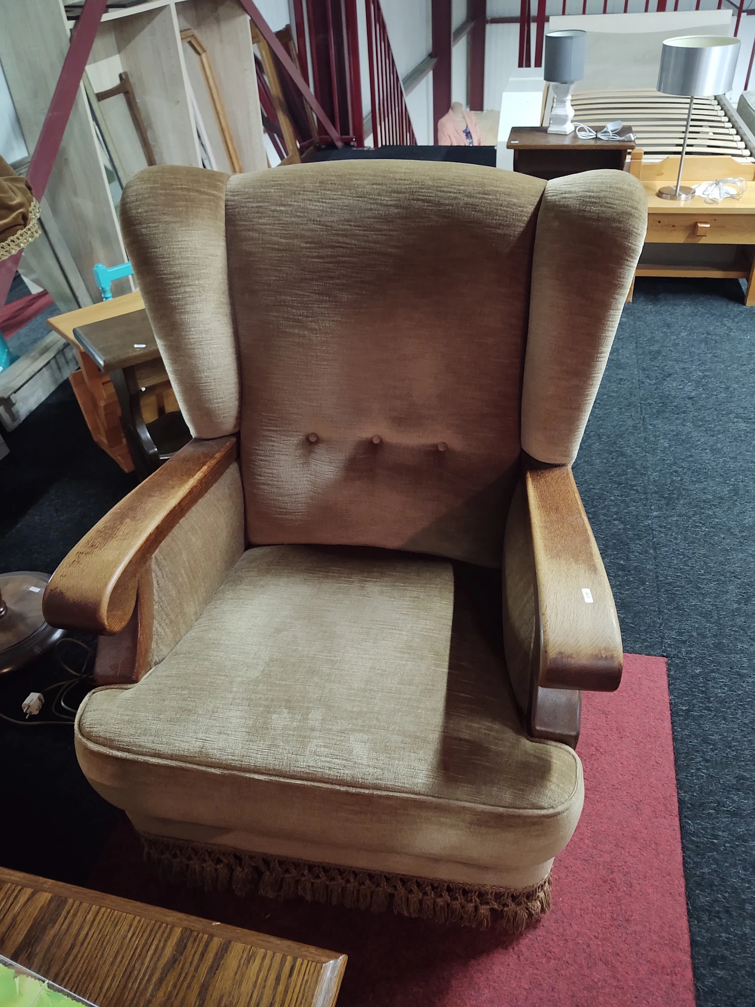 Bruine fauteuil met crème kleurige bekleding en houten armleuningen, gezien van voren