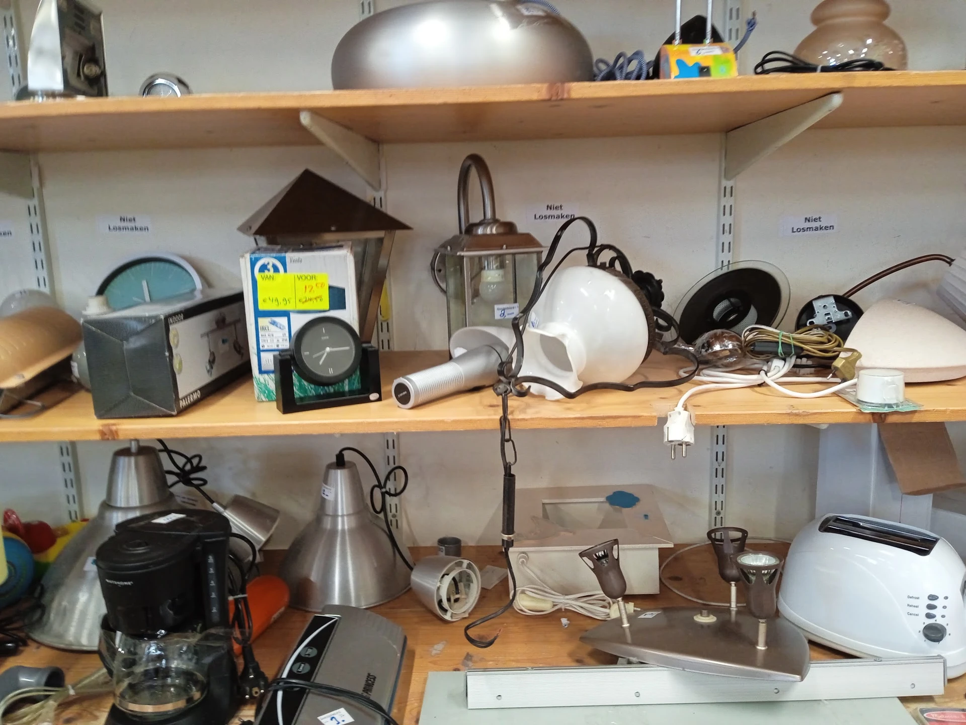 Houten stellingen met keukengerei, lampen, kookpotten en huishoudartikelen
