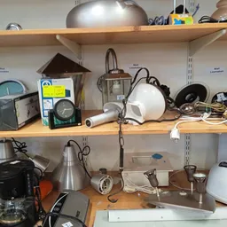 Houten stellingen met keukengerei, lampen, kookpotten en huishoudartikelen