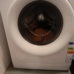 Binnenkant van een wasmachine met bruine/rode textiel