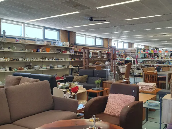 Zithoek met bruine fauteuils en boekenkasten tegen de muur in een kringloopwinkel