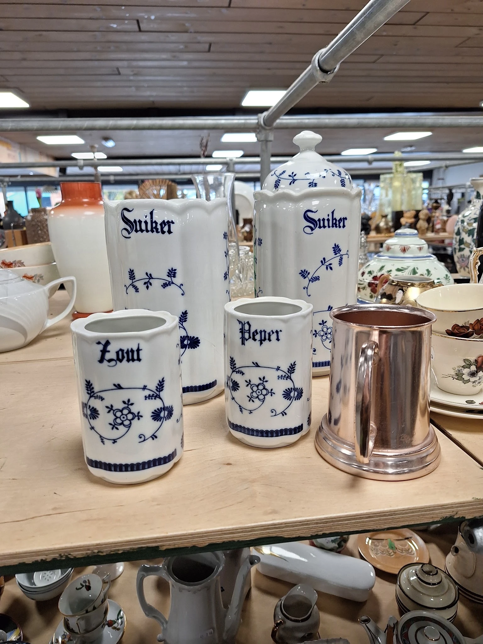 Blauw-wit porselein serviesgoed met scheepsdecoratieve motieven, waaronder zoutvaatjes, peperbussen en andere tafelstukken