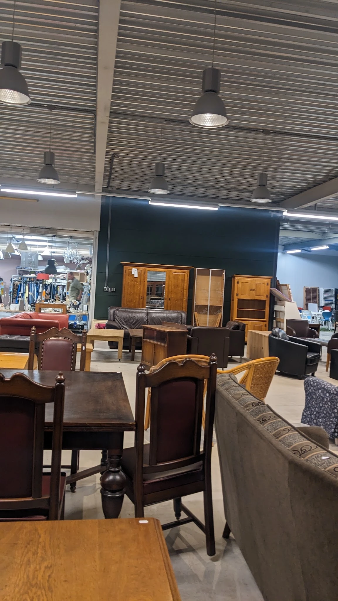Uitgestalde meubels in kringloopwinkel: kasten, stoelen, fauteuils en andere zitmeubelen