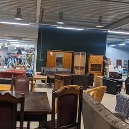 Uitgestalde meubels in kringloopwinkel: kasten, stoelen, fauteuils en andere zitmeubelen
