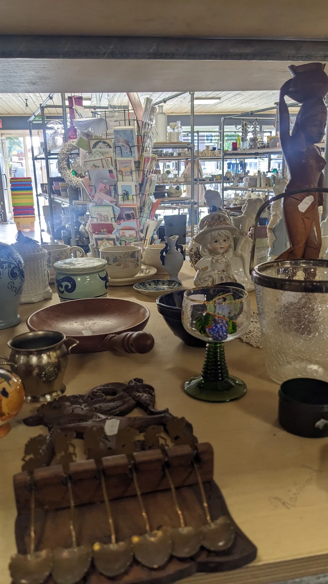 Tafel vol diverse tweedehands huishoudartikelen: servies, beeldjes, decoratieve objecten en aardewerk