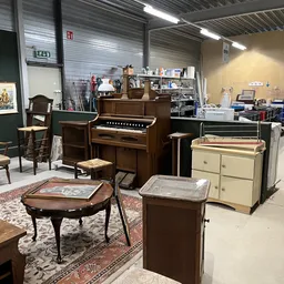 Winkelvloer met antieke meubels: piano, stoelen, tafels en kasten op Perzisch tapijt
