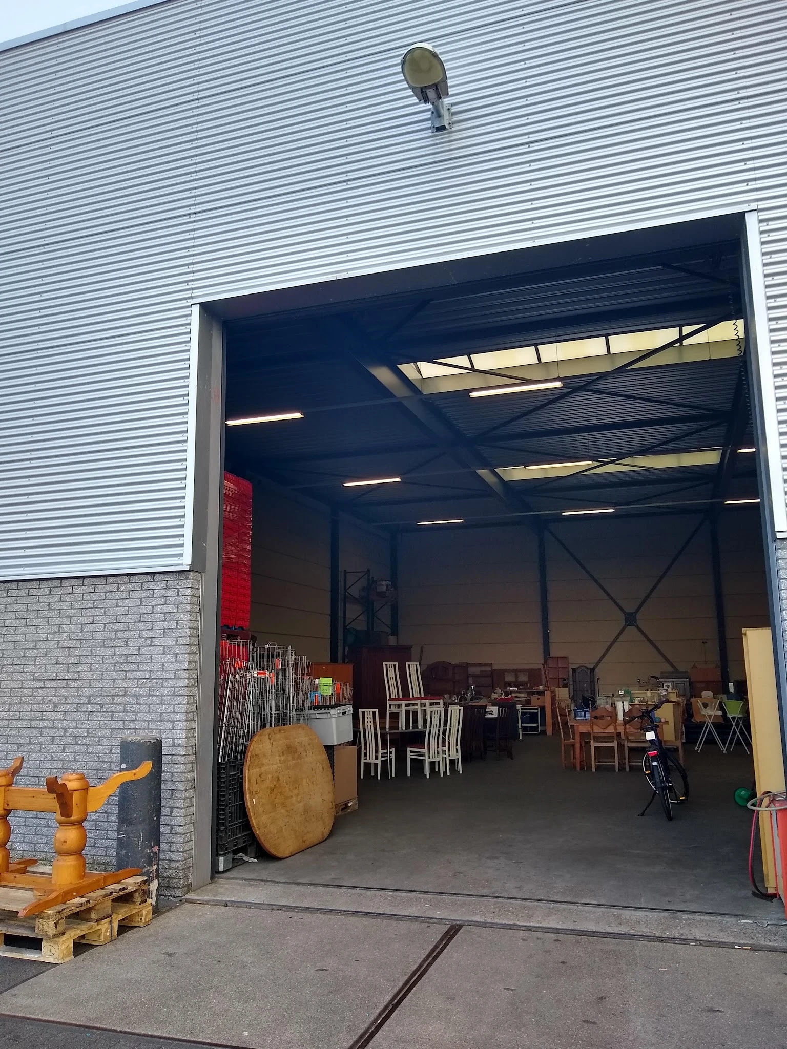 Ruime opslagruimte met diverse meubels en spullen, met industrieel plafond met skylight