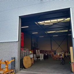 Ruime opslagruimte met diverse meubels en spullen, met industrieel plafond met skylight