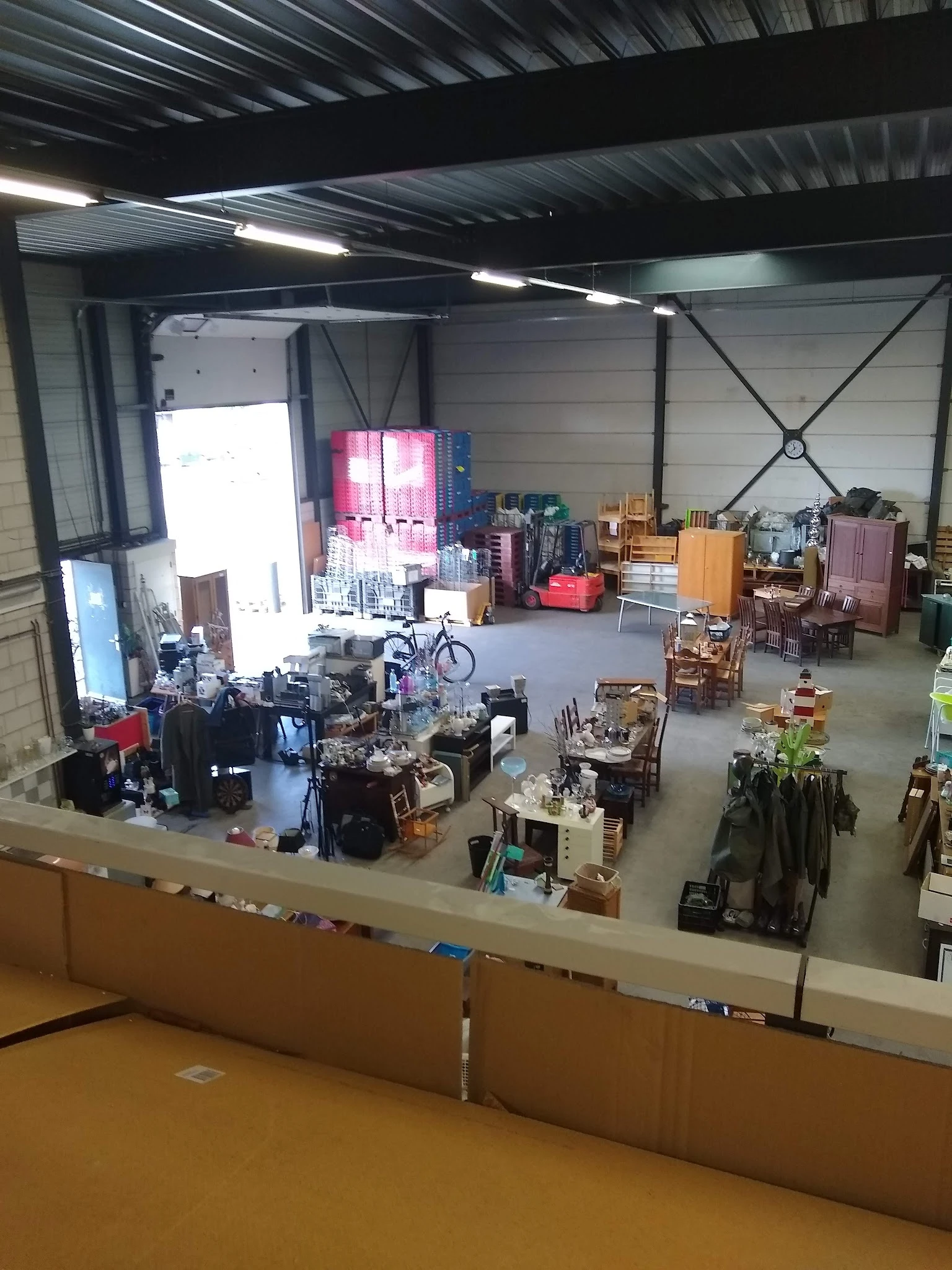 Overzicht van een kringloopwinkelruimte met meubels, fietsen en huishoudartikelen; gefotografeerd vanuit bovenaanzicht
