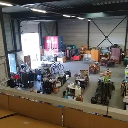Overzicht van een kringloopwinkelruimte met meubels, fietsen en huishoudartikelen; gefotografeerd vanuit bovenaanzicht