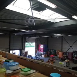 Overzicht van de winkelruimte met stellingen, opgestelde spullen en een ingang aan het einde