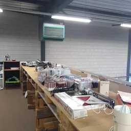 Lange tafel vol met diverse huishoudartikelen, electronica en spullen in kringloopwinkel