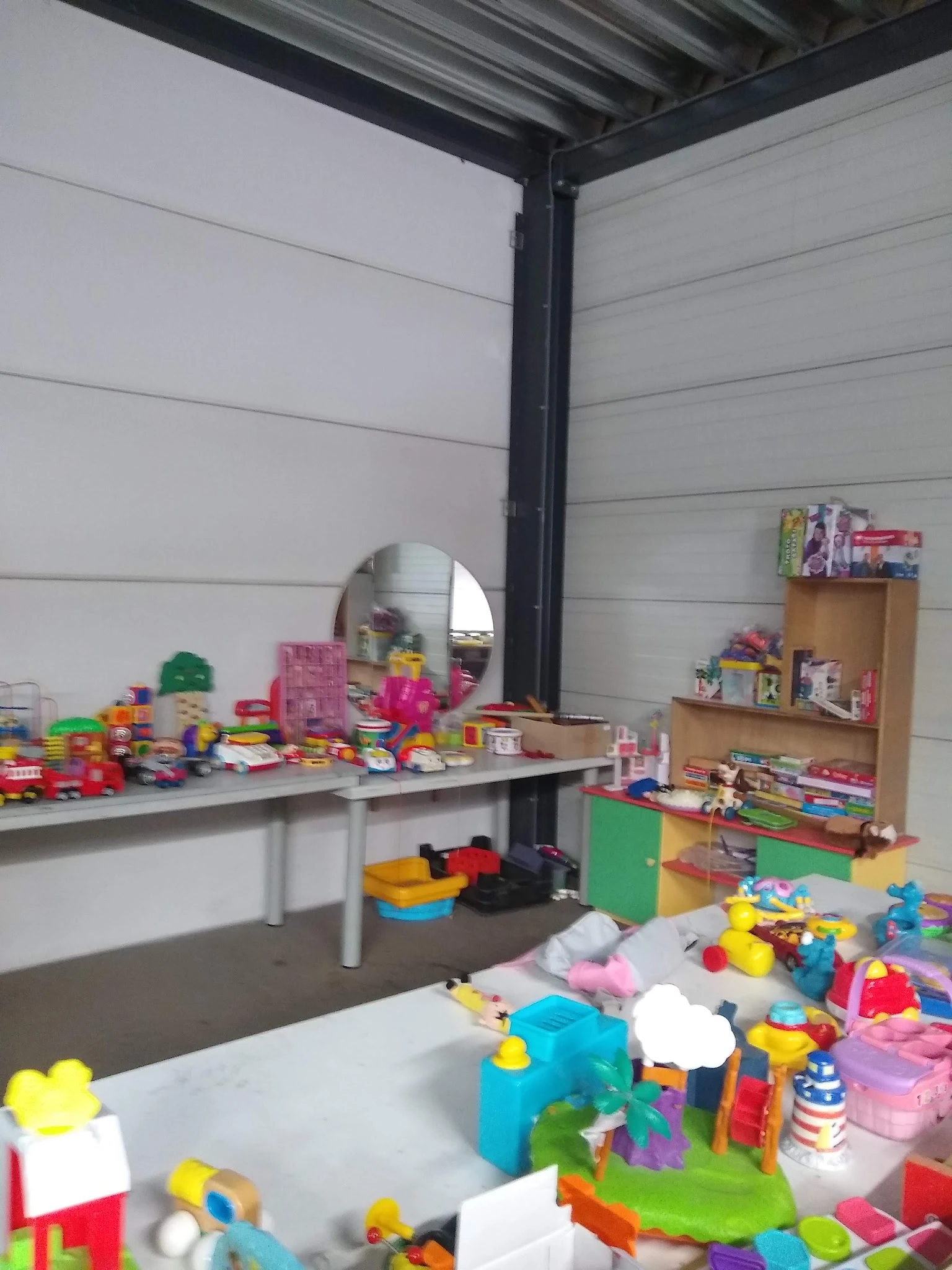 Speelgoed en kunststofartikelen uitgestald op tafels en stellingen in de winkel