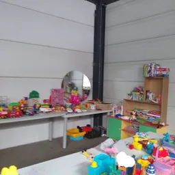 Speelgoed en kunststofartikelen uitgestald op tafels en stellingen in de winkel