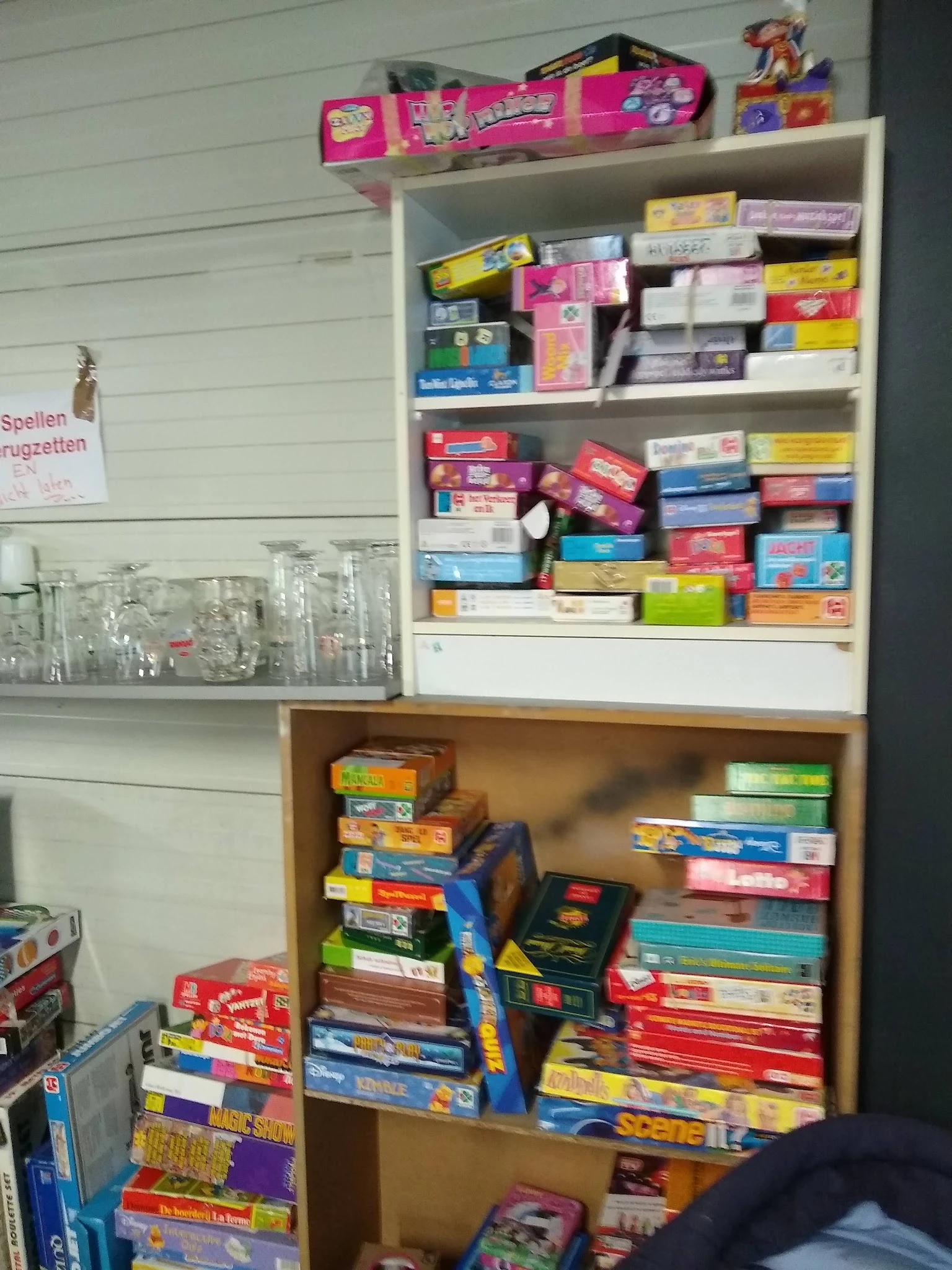 Stellingen vol gekleurde dozen met bordspellen en puzzels in verschillende stapels