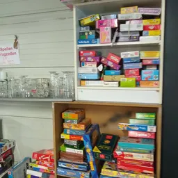 Stellingen vol gekleurde dozen met bordspellen en puzzels in verschillende stapels