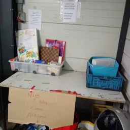 Werkplek met opbergboxen, dozen en spullen op een tafel tegen witte wand