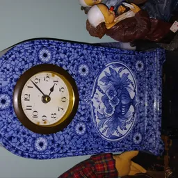 Blauwe klok met wit wijzerplaat en Delfts blauw decoratie met vogelpatroon