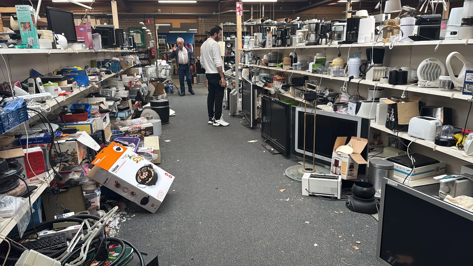 Winkelvloer van kringloopwinkel met stellingen vol huishoudartikelen, apparaten en diverse spullen
