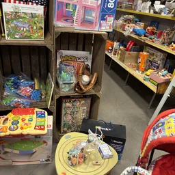 Winkelinterieur met stellingen vol speelgoed, spellen en kinderartikelen
