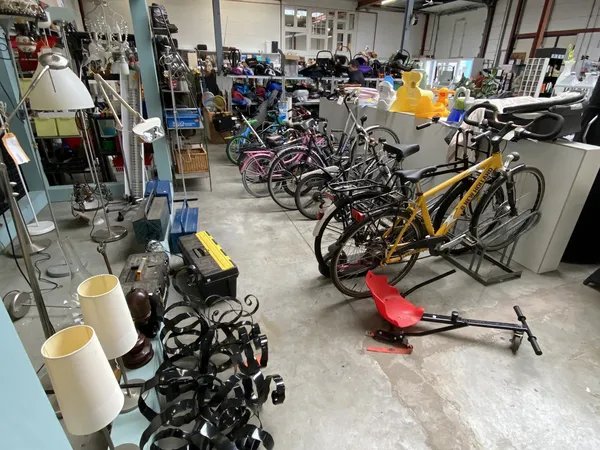 Winkelvloer met uitgestalde fietsen, fietsonderdelen en overige spullen in een kringloopwinkel