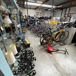 Winkelvloer met uitgestalde fietsen, onderdelen en overige spullen in een kringloopwinkel